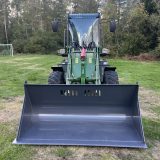 Lastmaskin Skipsna T8600 rakt framifrån med bred lastskopa, strålkastare och arbetsljus på hytten