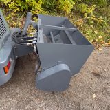 Närbild på sandspridarens hydraulslangar och skyddskåpa – redskap till hjullastare